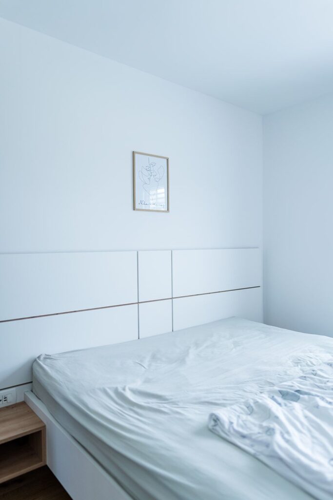 Spalnica z belim posteljnim vzglavjem