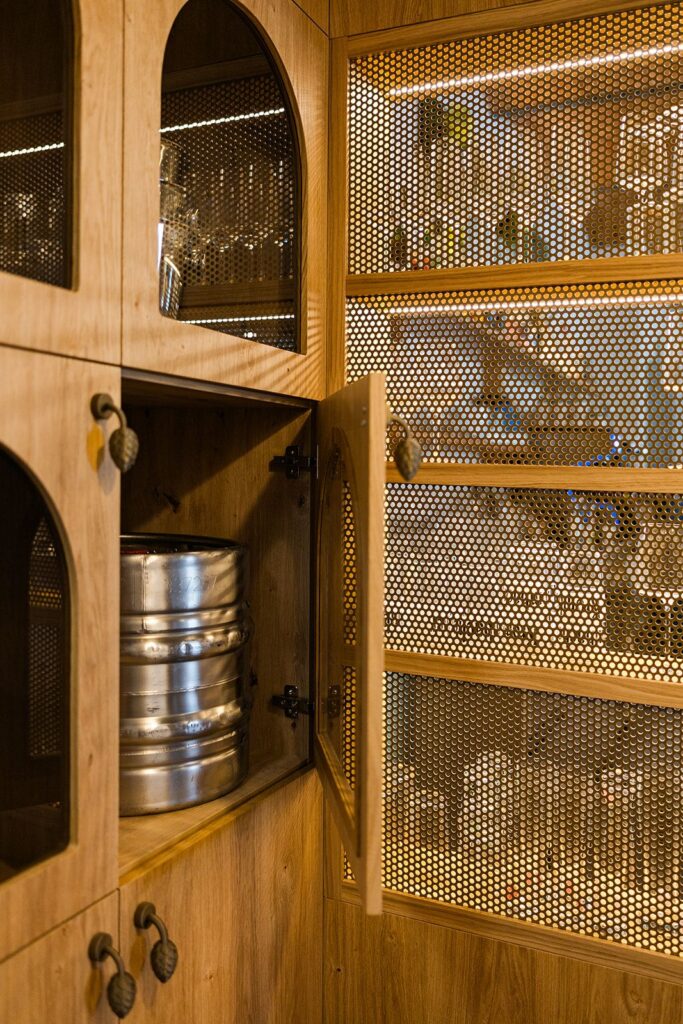 Odprta lesena omara s kozarci in pivskim sodčkom