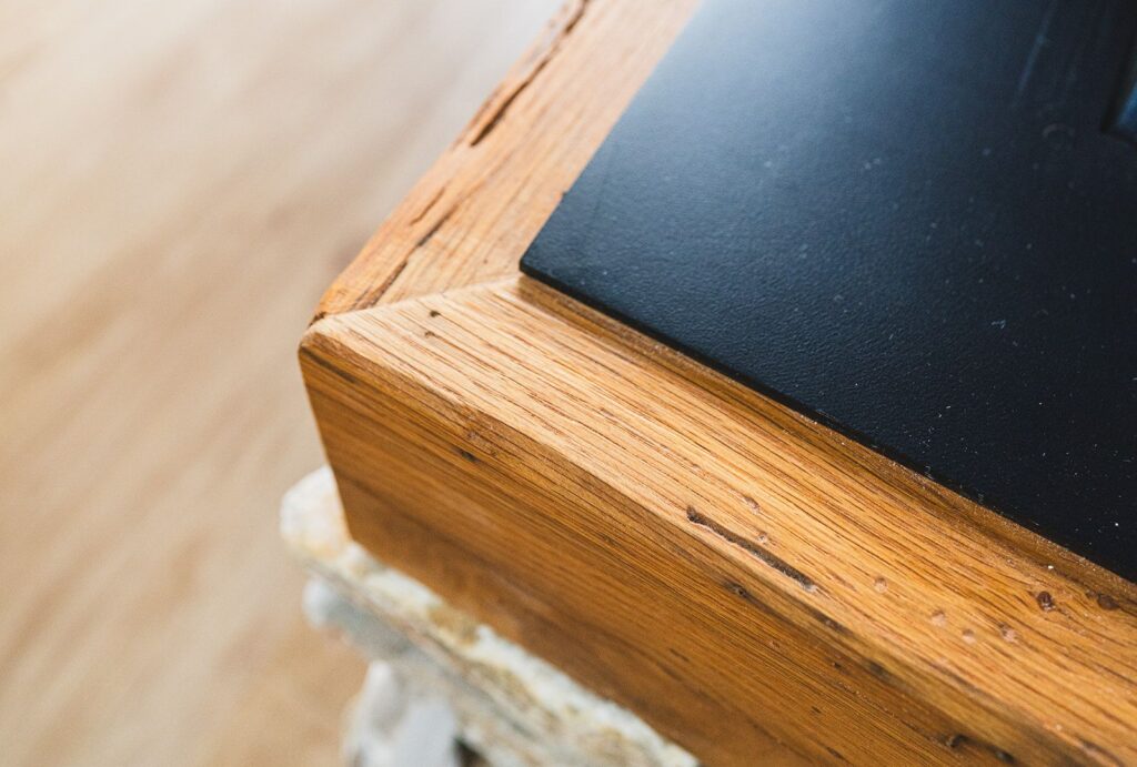 Vogal kamina s črno ploščo in leseno obrobo