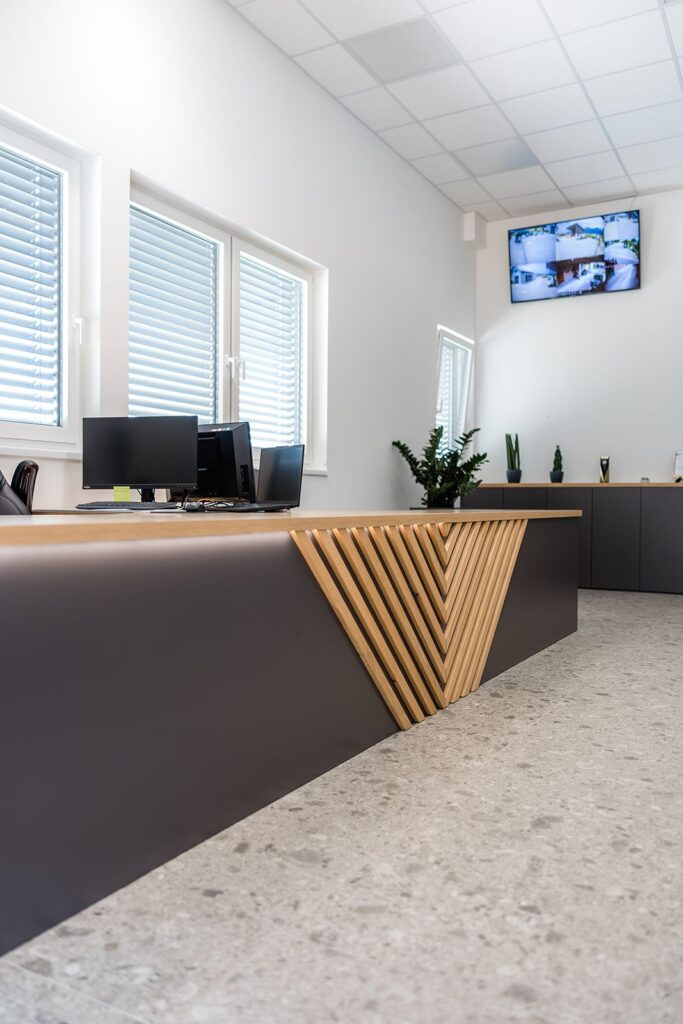 Temen recepcijski pult z diagonalnimi letvami in delovnimi mesti